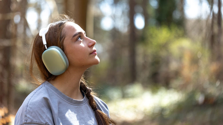 A woman in the woods wearing headphones