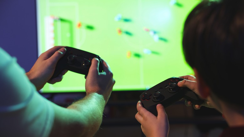 A father and son playing video games together.