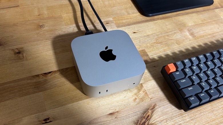 A Mac Mini set up on a desk with a keyboard alongside it