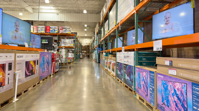 TV aisle at Costco with assorted variety of electronics on sale.
