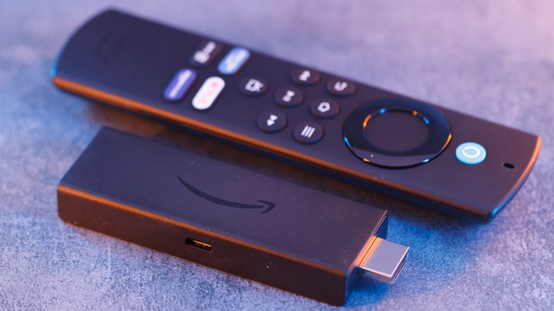 Amazon Fire TV Stick placed on a carpet with its remote