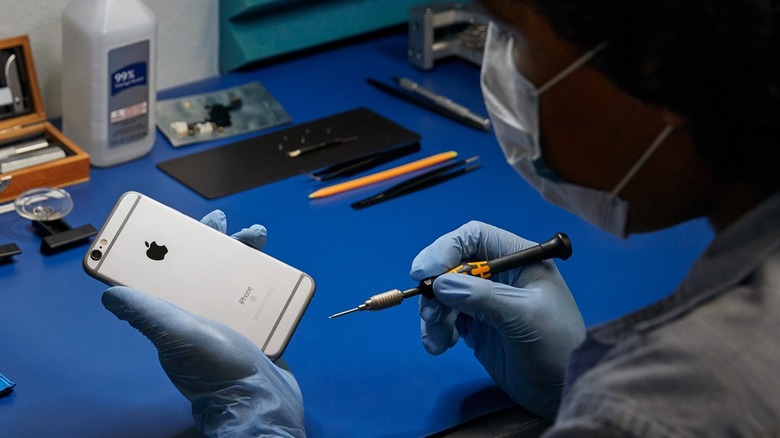 A woman repairing an iPhone 6