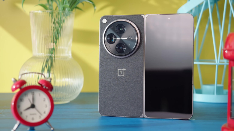 A OnePlus smartphone perched upright on a table.