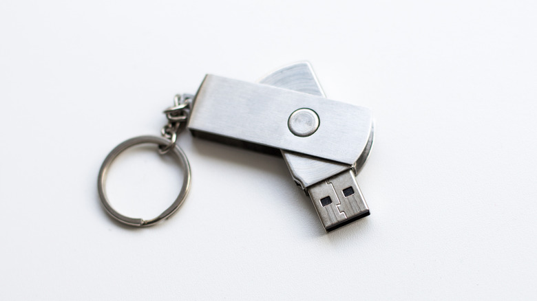 A metal flash drive embedded in a small keyring.