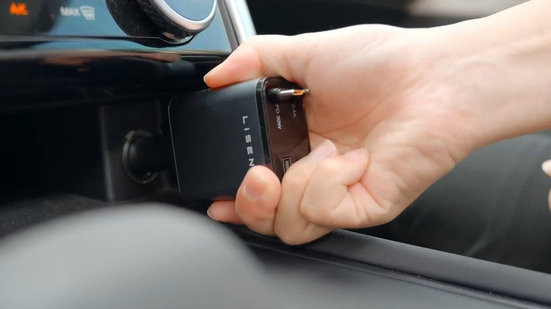 Hand plugging in Lisen Retractable Car Charger into car's 12V port