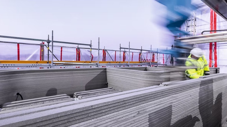 A high-speed photo of a construction worker using a 3D printing device.