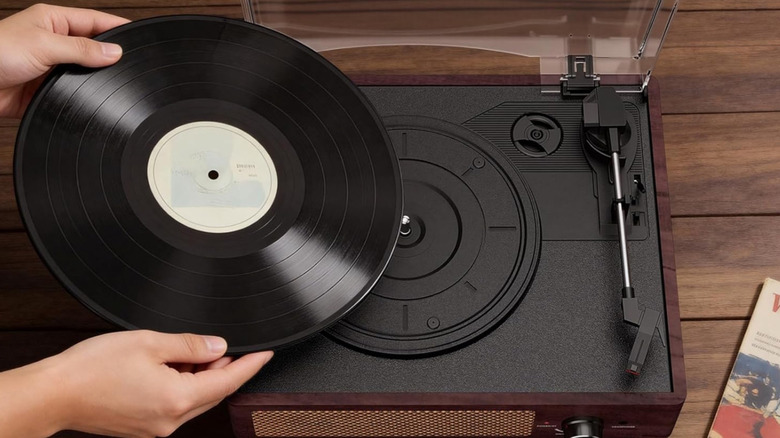 A person putting a record on a COTSOCO turntable.