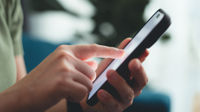 Person using their smartphone with the display on.