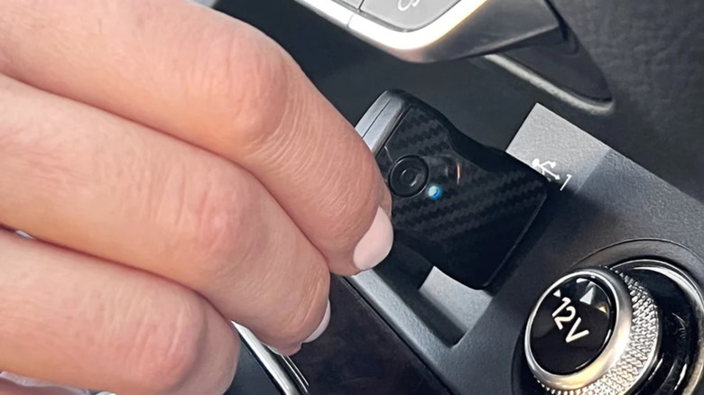 Person plugging the Aluratek wireless adapter into a car port