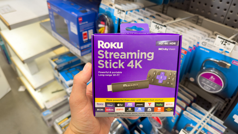 Close-up of a person holding a Roku Streaking Stick 4K in a store