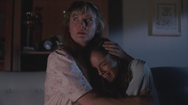 Nadine Van der Velde being held by Dee Wallace in Critters