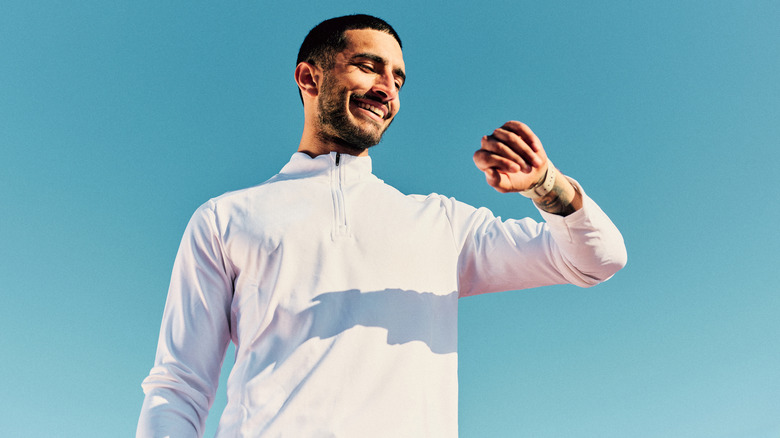 a man in athletic clothes looking at his smartwatch