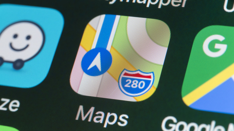 Apple maps logo next to Google maps and waze icons on iPhone home screen