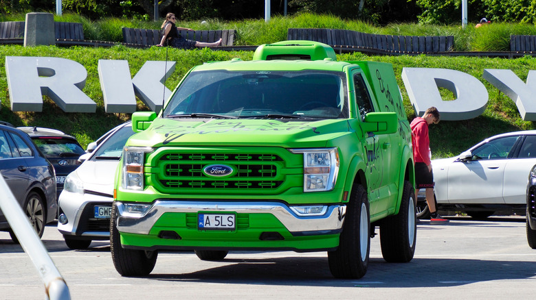 A green Ford F-150 Lightning electric pickup truck parked in a parking lot