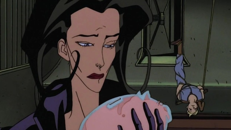 The lead character of the MTV series "Aeon Flux" holding a pink pig as someone is tied-up behind them