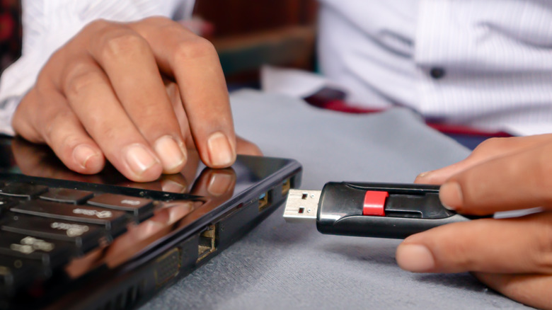 A flash drive being inserted into a laptop