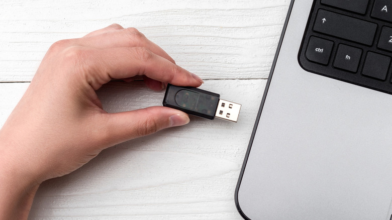 A flash drive being inserted into a laptop