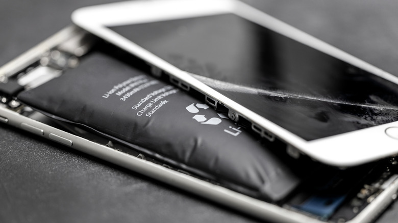 Visibly expanded smartphone battery with display removed from phone chassis