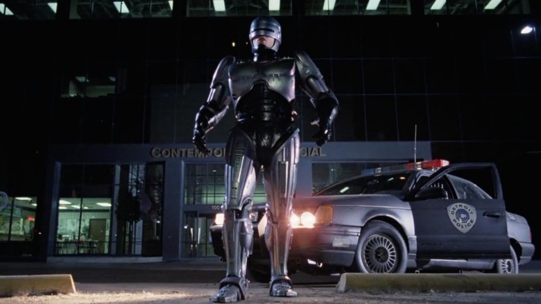 RoboCop walking in front of his police car in RoboCop