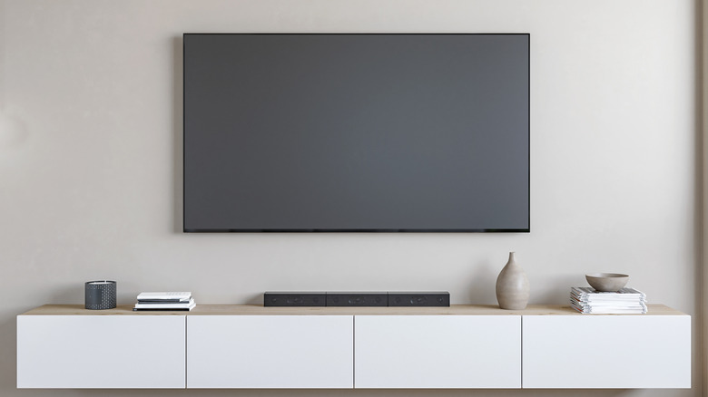 A wall-mounted TV with an entertainment stand
