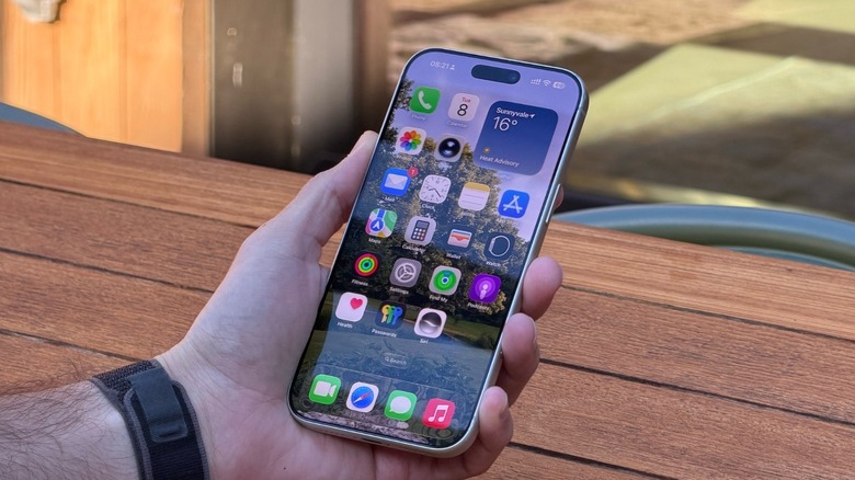A man holding an iPhone running iOS 27