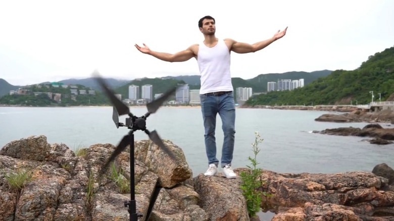 A man outdoors by the water with his mini turbine
