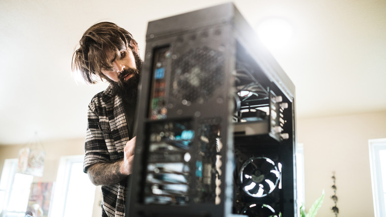 Man working on his PC with the cover removed