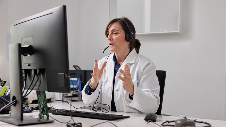 A telehealth doctor meeting with a patient on her computer
