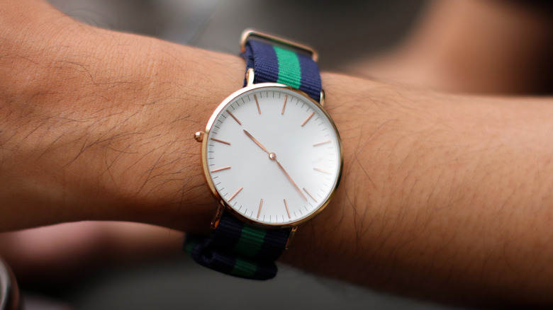 A cloth-strapped wristwatch on someone's wrist