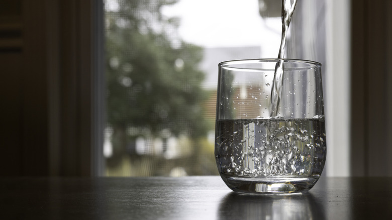 Drinking water poured into a small glass.