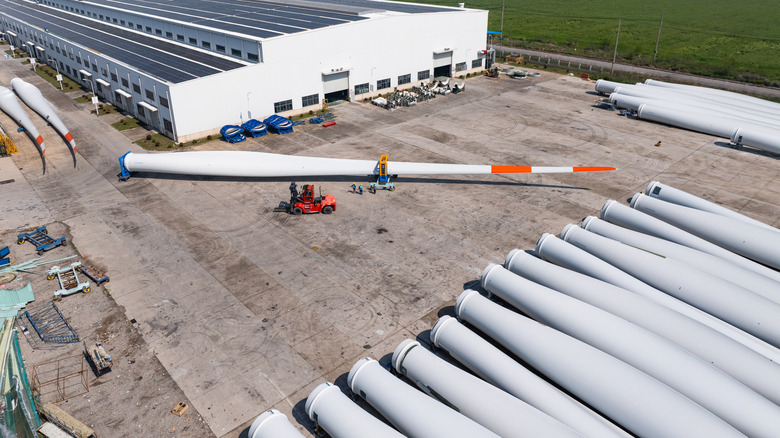 Wind turbines stacked in a yard.