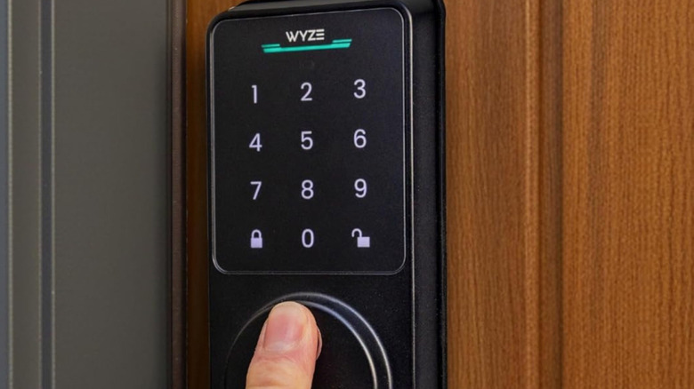 A finger placed on the fingerprint scanner of the Wyze Auto-Lock Bolt v2.