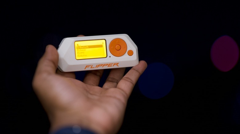 Flipper Zero in someones hands with the screen on and settings visible.
