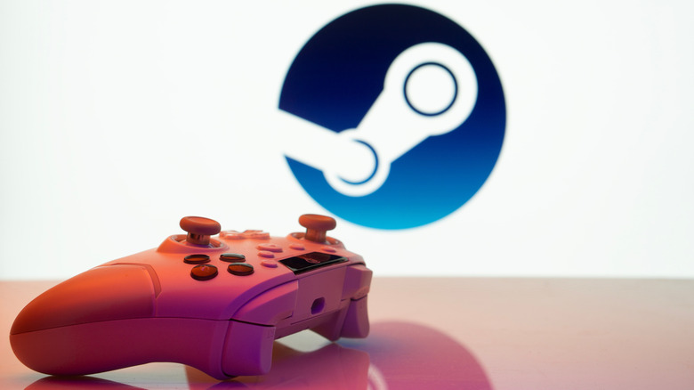 A red game controller on a glossy table with a blurry Steam logo in the background.