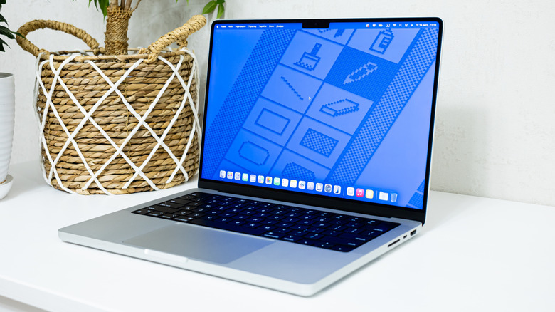 A MacBook Pro on a desk with the palm rest visible.