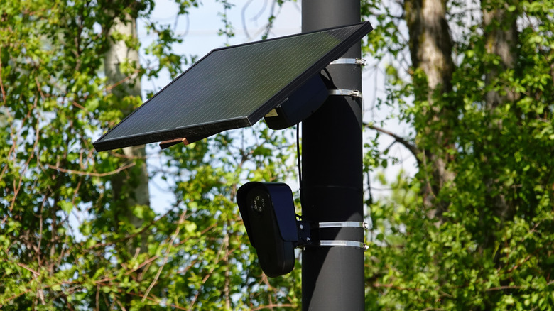 Flock automated license plate readers setup on traffic pole with solar panel installed above.