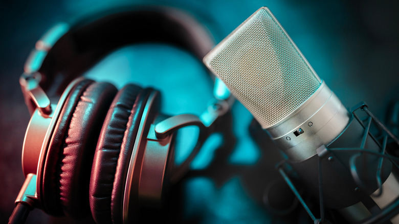 A pair of studio headphones next to a studio condenser microphone