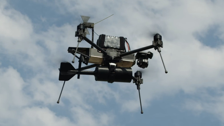 A Linza drone hovers in the sky while carrying a small explosive device.