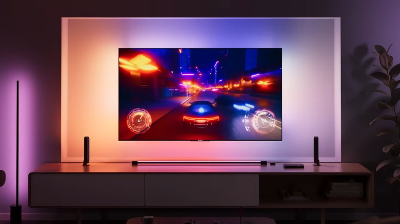 The Philips Hue Play HDMI Sync Box 8K set up with a wall-mounted TV and three light bar accessories.