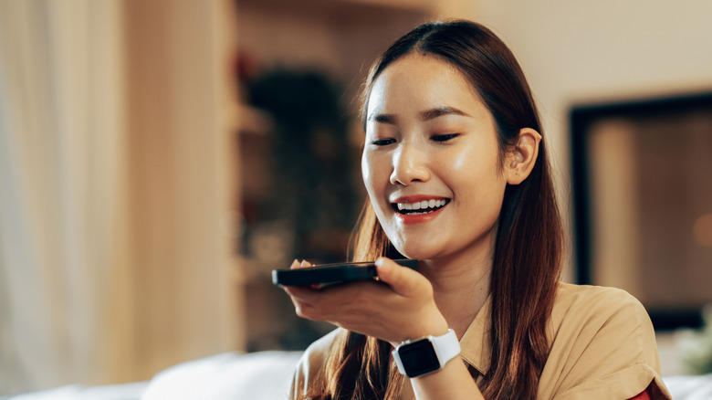 A woman manipulating an iPhone by voice