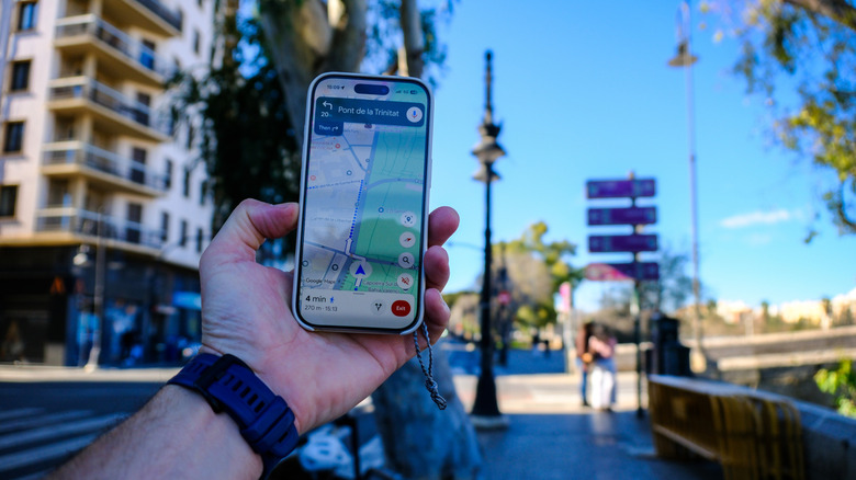 A person using Google Maps to navigate a city while walking.