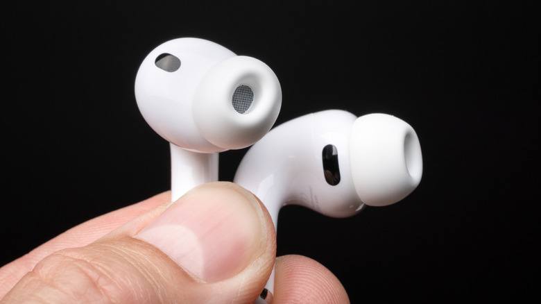 A person holding a pair of AirPods Pro 3.