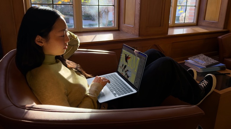 Woman using a MacBook Air laptop on a chair