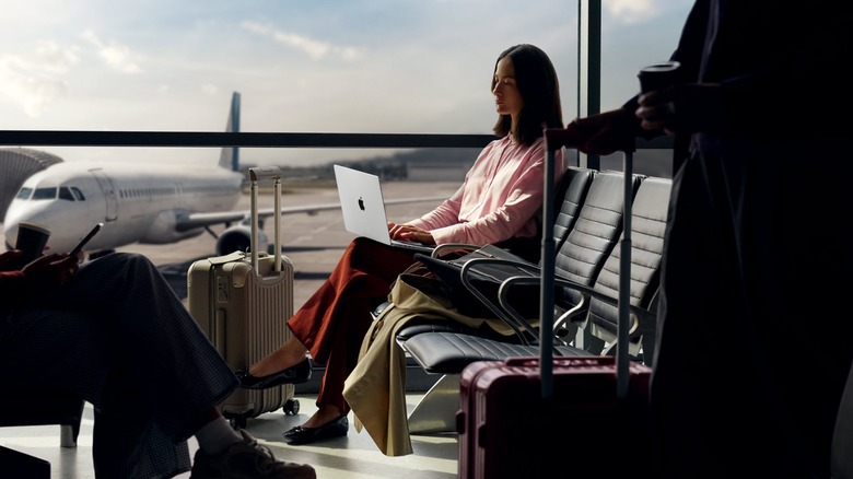 Woman using MacBook Pro in airport