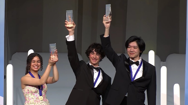 Matteo Paz (center) at Regeneron Science Talent Search holding up prize