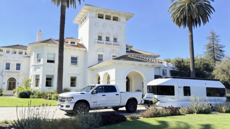 Truck with the Skydream trailer hitched in the driveway of a home.