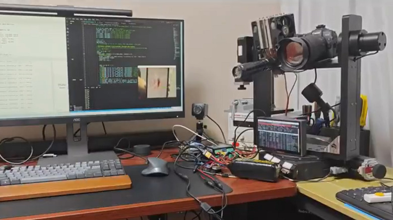 Steven Cheng's mosquito-killing laser system alongside a PC monitor and keyboard on a desk
