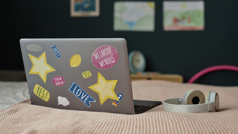 A stickered laptop placed on a blanket