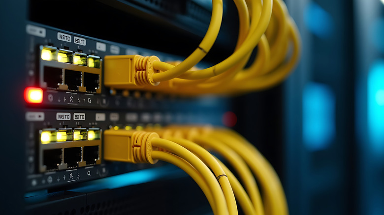 Close up view of a network switch with multiple yellow Ethernet cables plugged in