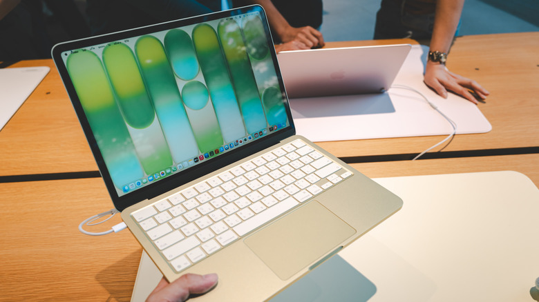 A customer exploring and testing the features of the MacBook Neo at an Apple Store